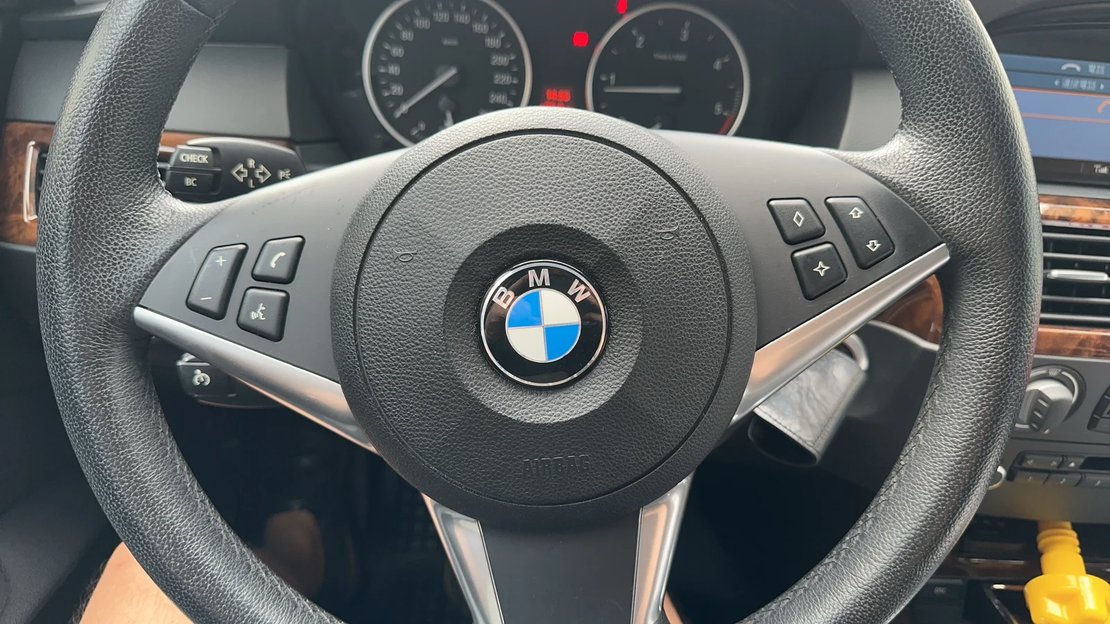 BMW E60 的方向盤與後方的儀表板，方向盤中央是 BMW 廠徽